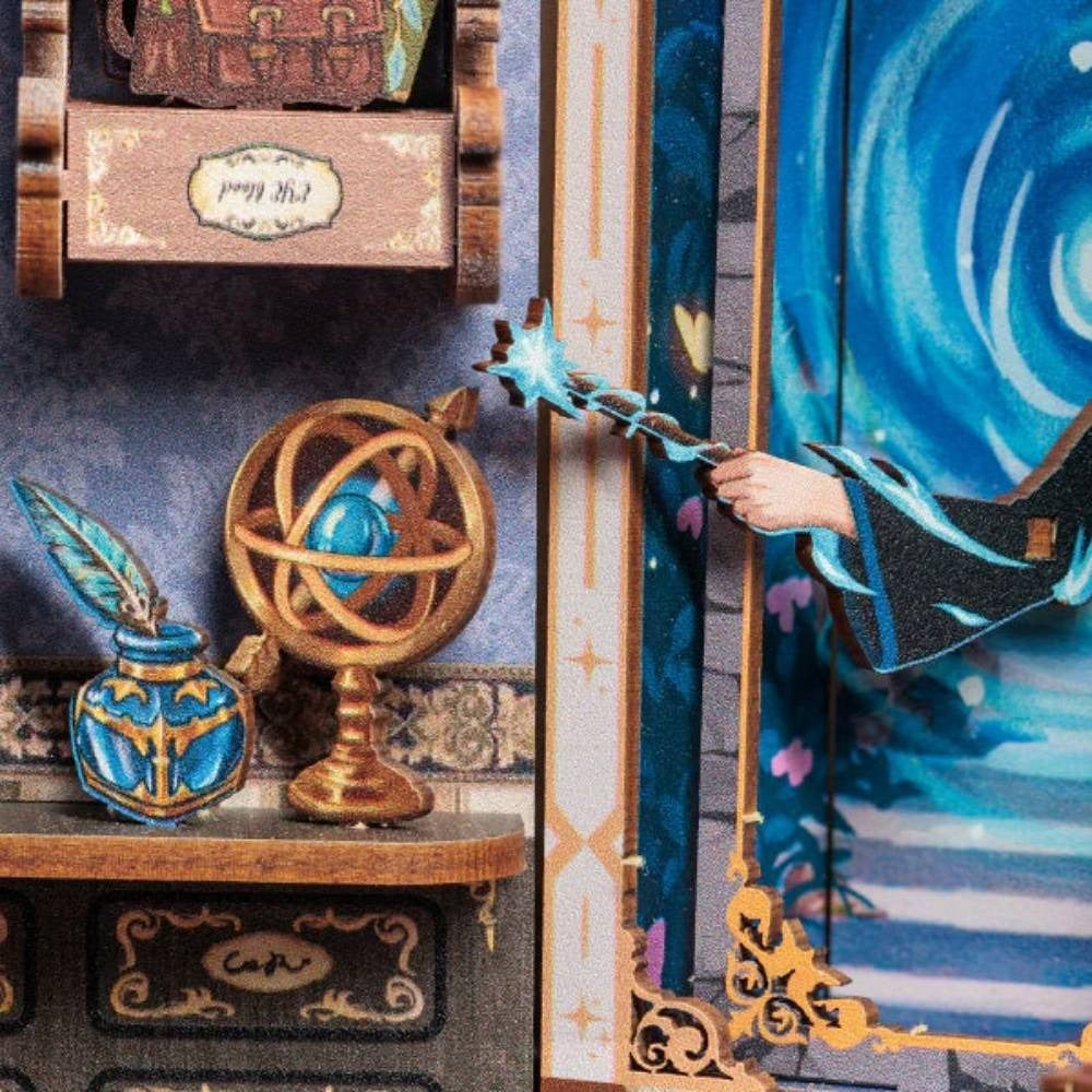 Encrier, plume et portail bleu du book nook agence de voyage enchantée