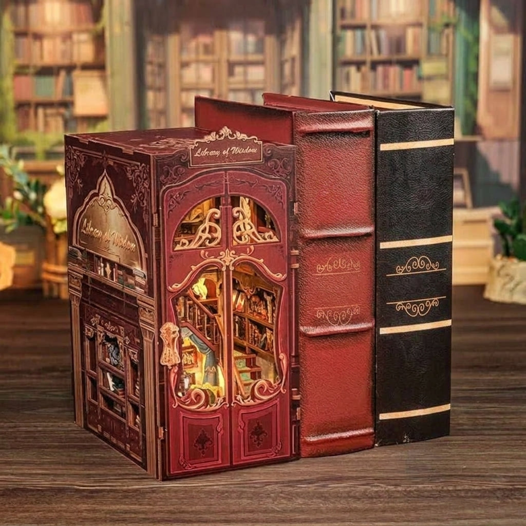 Book nook bibliothèque aux portes rouges posé à côté de deux gros livres reliés