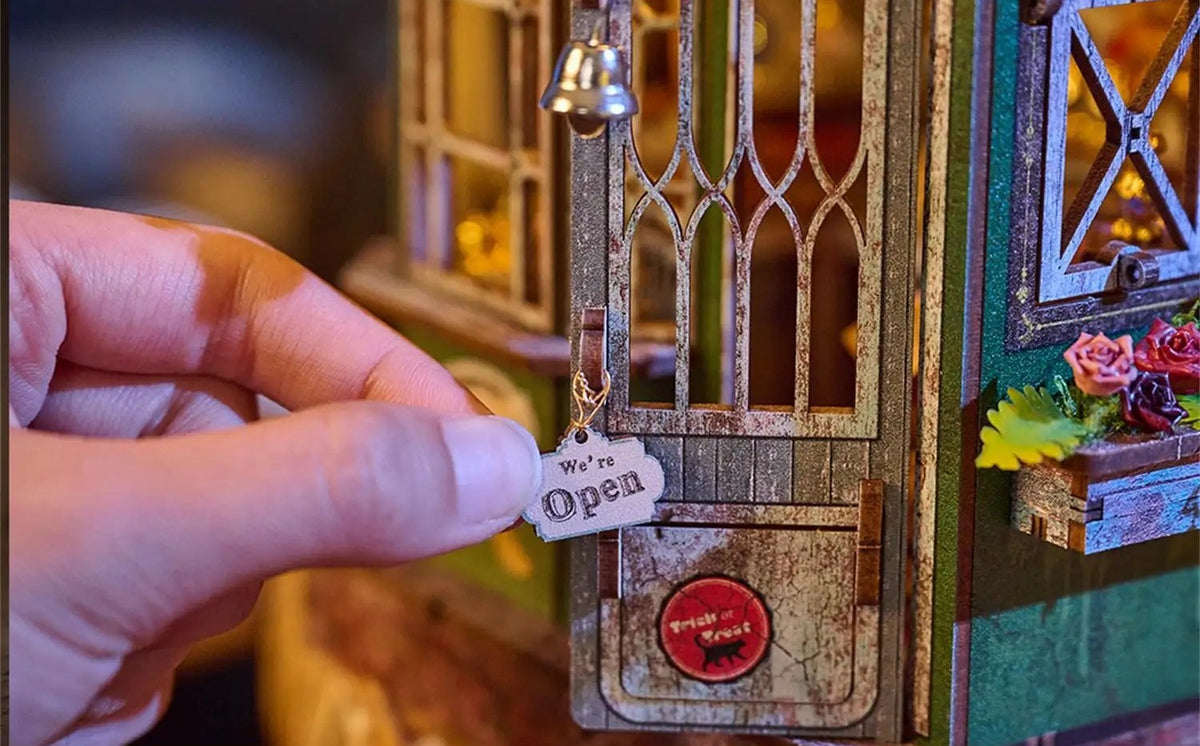 Porte vitrée à clochette et pancarte « Open » du book nook boutique de magie