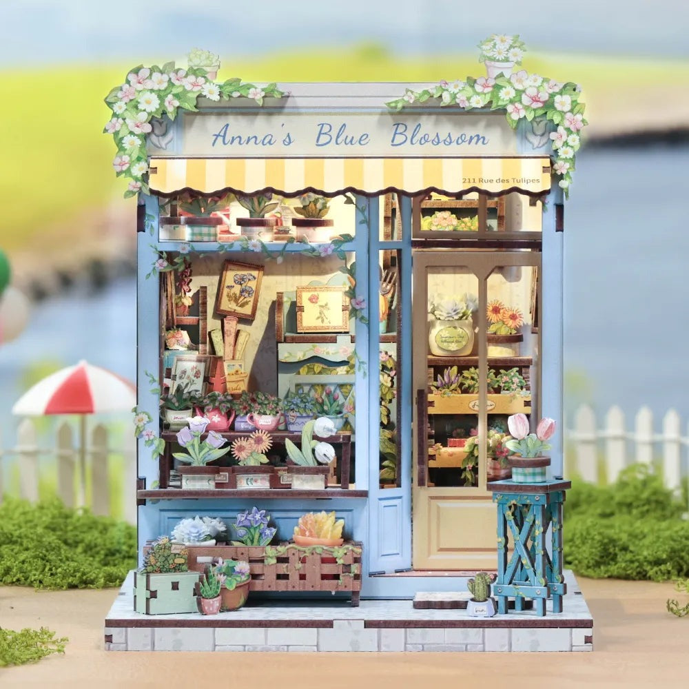 Book nook fleuriste posé dans un jardin, devant une barrière blanche