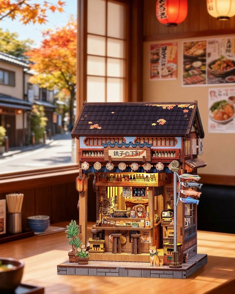 Book nook izakaya japonais posé sur une table de restaurant, érables en arrière-plan