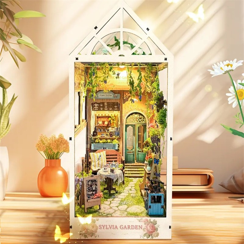 Book nook jardin secret sous verrière posé sur un meuble au soleil