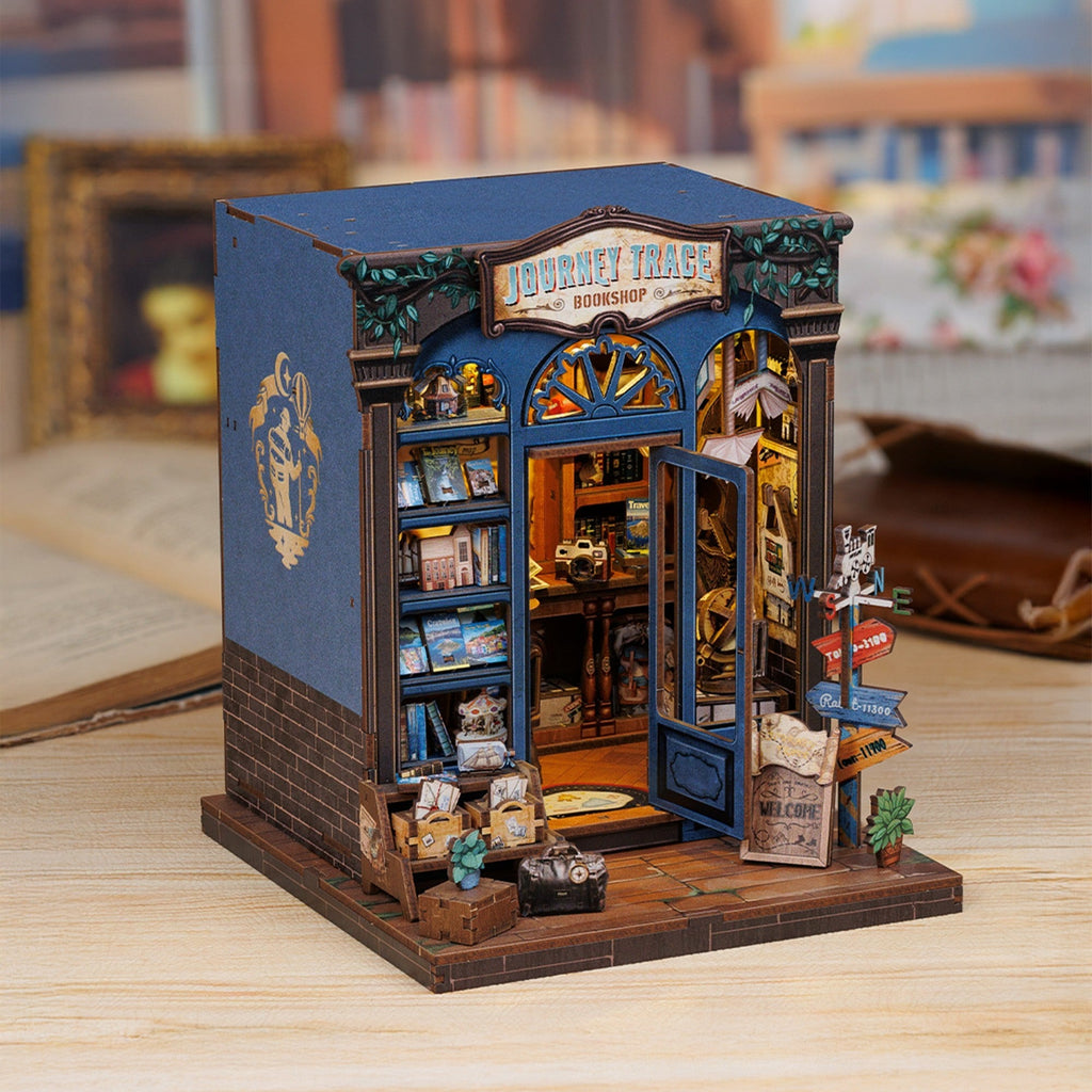 Book nook librairie du voyage posé sur une table en bois, briques et façade bleue