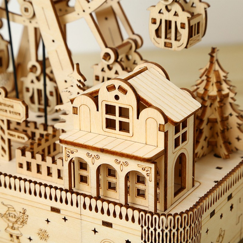 Détail de la petite maison et du sapin sur le socle de la grande roue en bois