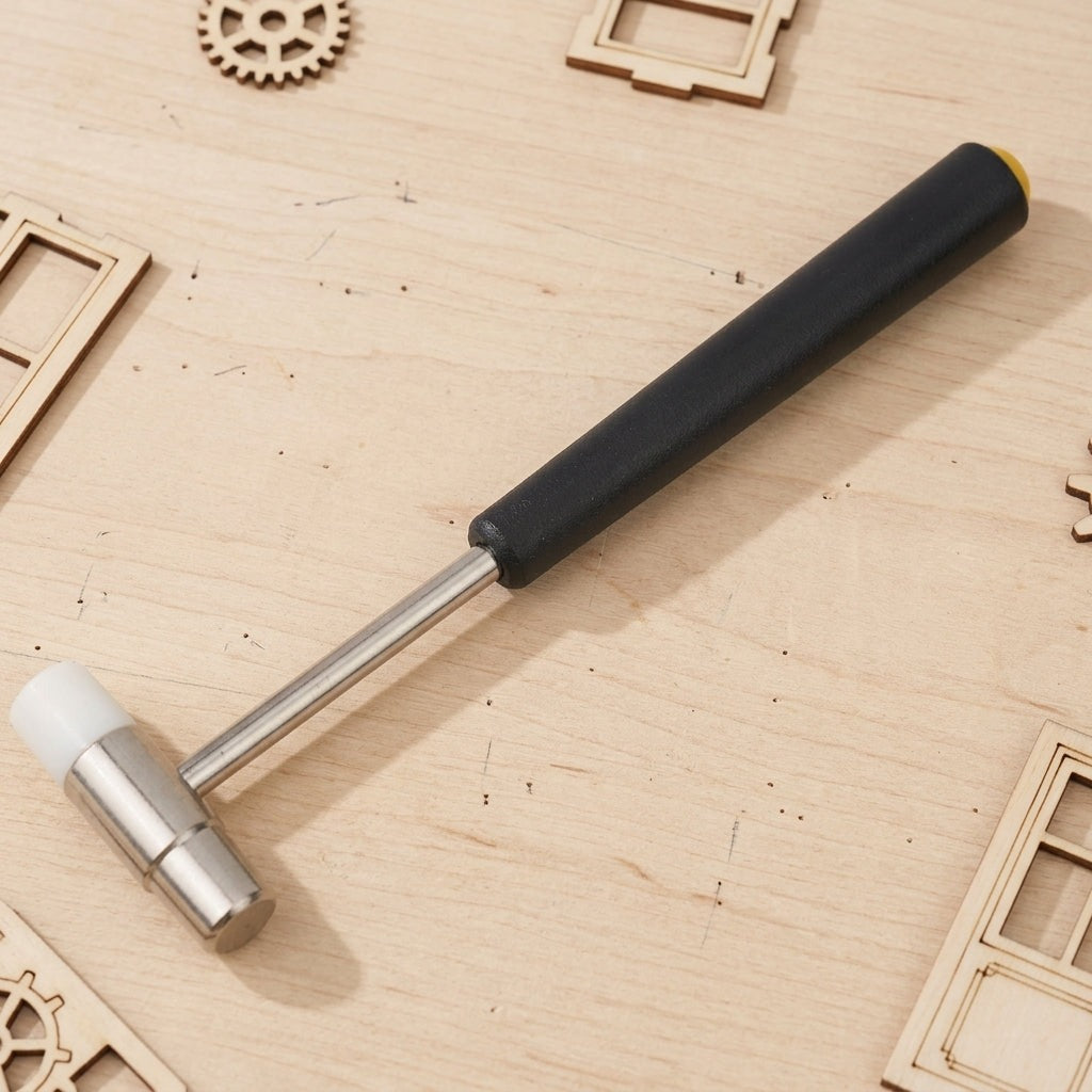 Marteau de précision posé sur un plan de travail parmi des pièces de maquette en bois découpées